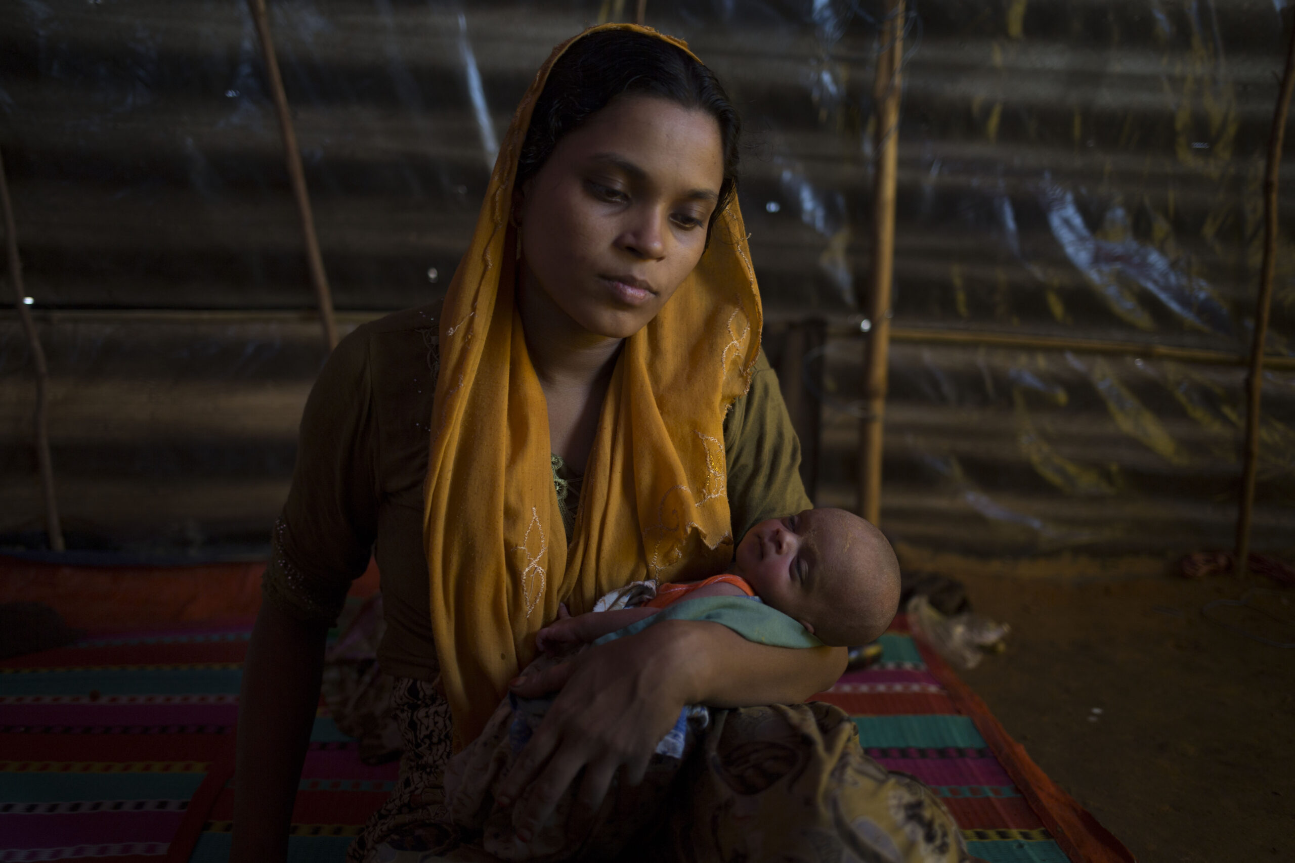 Den unge moren Minara sitter sammen med sin uke gamle datter i Bangladesh. Minara måtte flykte sammen med ektemannen fra landsbyen Ludang i Myanmar på grunn av vold. Foto: Ajghani, British Red Cross